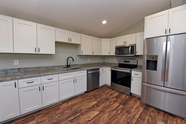 kitchen featuring light stone countertops, appliances with stainless steel finishes, white cabinets, and a sink