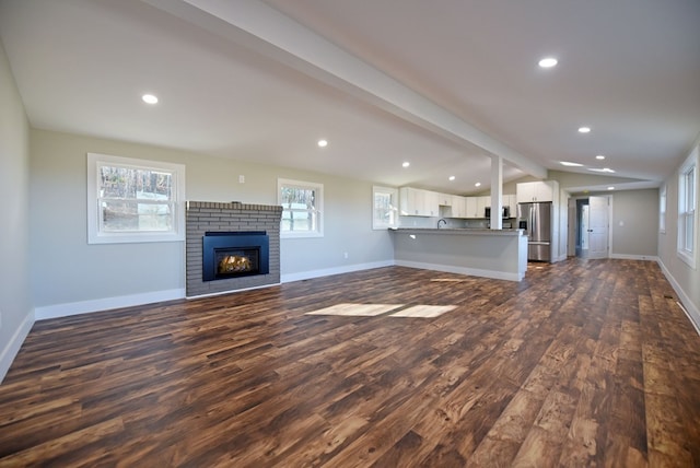 16 Sims Rd, Hiawassee, GA 30546 - unfurnished living room featuring lofted ceiling with beams, dark wood-style flooring, and baseboards