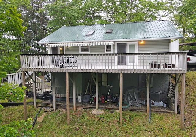rear view of property with metal roof, cooling unit, a deck, and stairway