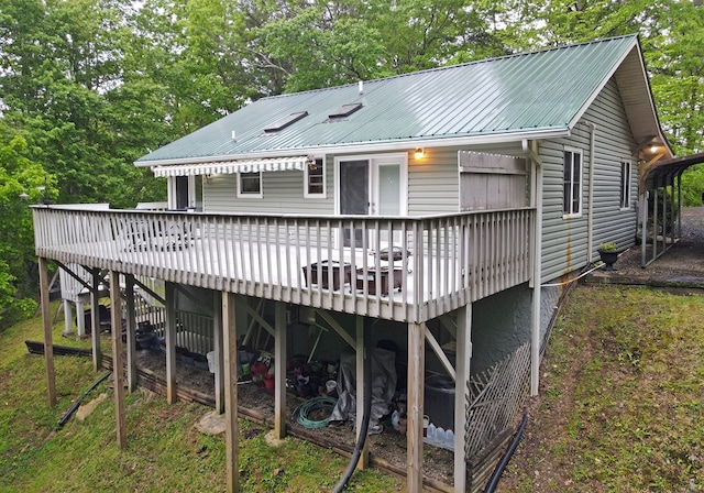 back of property with a wooden deck, stairs, and metal roof
