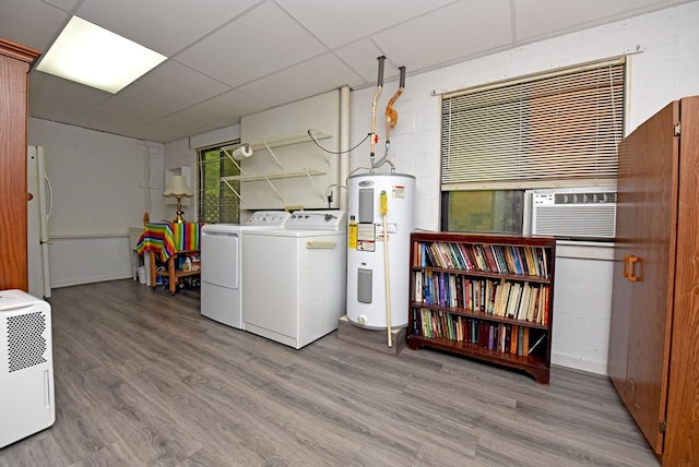 clothes washing area with wood finished floors, water heater, and independent washer and dryer