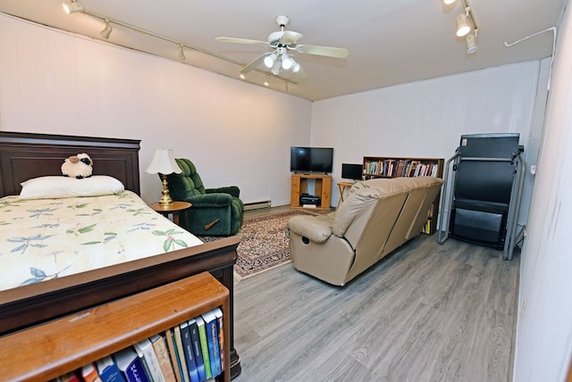 bedroom with track lighting, a baseboard radiator, a ceiling fan, and wood finished floors