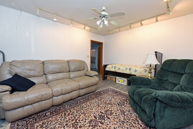 living room featuring track lighting, ceiling fan, and wood finished floors