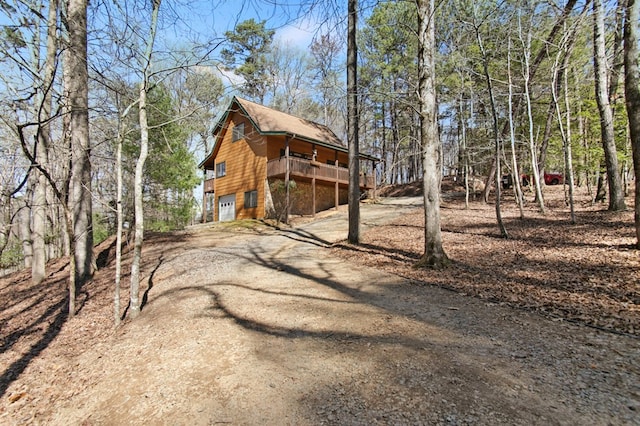 view of home's exterior with an attached garage and dirt driveway