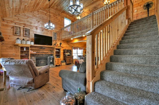 living room with wood walls, wood-type flooring, and stairway