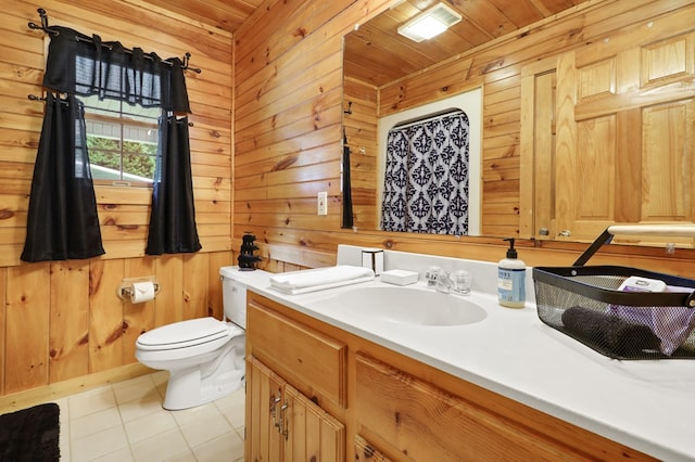 bathroom featuring wood walls, vanity, toilet, wooden ceiling, and tile patterned floors