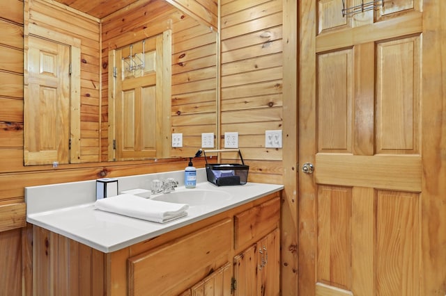 bathroom featuring vanity and wooden walls