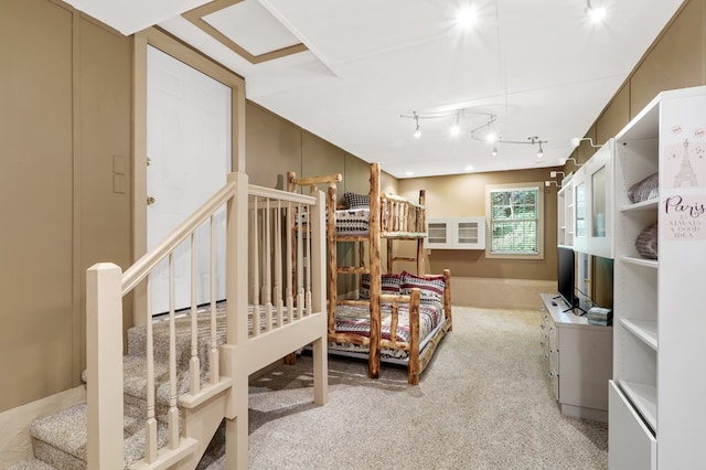 carpeted bedroom featuring track lighting and a wall unit AC