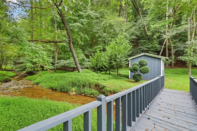 wooden deck featuring a shed and a water view