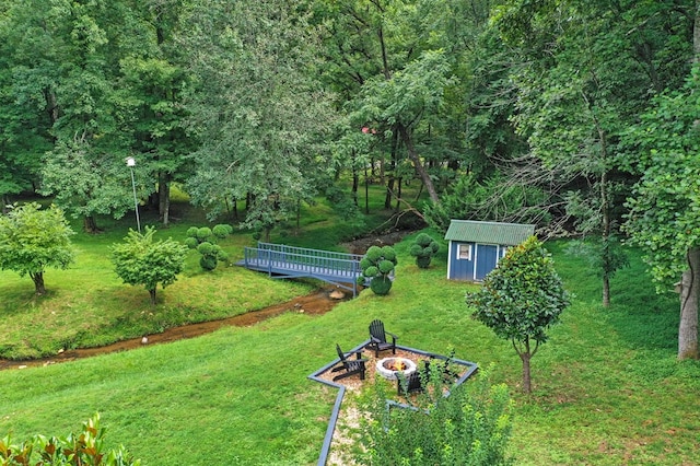 view of yard with a storage shed and a fire pit