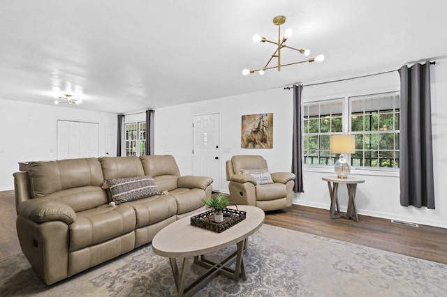 living room with hardwood / wood-style flooring and an inviting chandelier