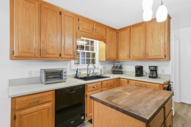 kitchen with a kitchen island, decorative light fixtures, black dishwasher, sink, and hardwood / wood-style flooring