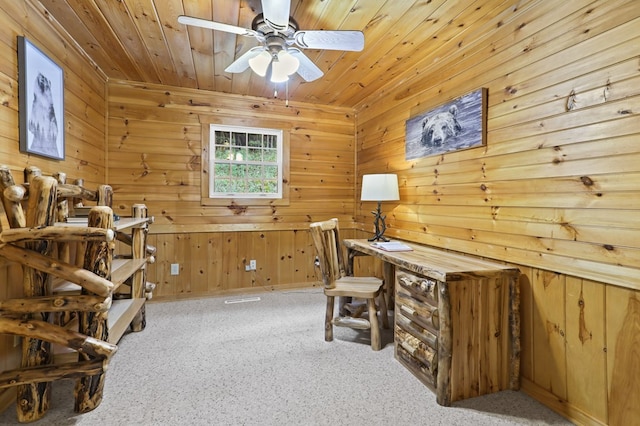 carpeted home office featuring ceiling fan, wooden walls, and wood ceiling