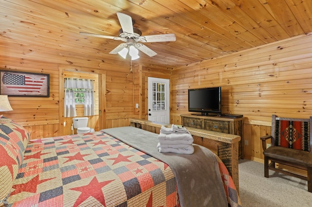 carpeted bedroom featuring wood ceiling, ceiling fan, and wooden walls