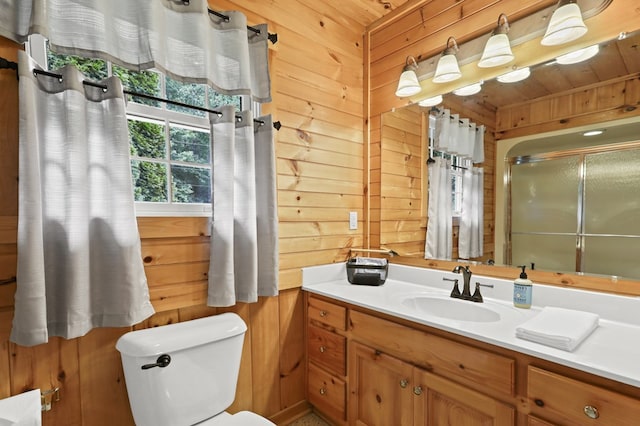 bathroom with vanity, wooden walls, and toilet