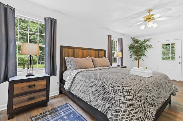 bedroom featuring multiple windows, ceiling fan, and dark hardwood / wood-style flooring