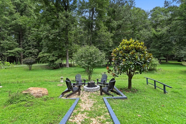 view of property's community with a yard and an outdoor fire pit