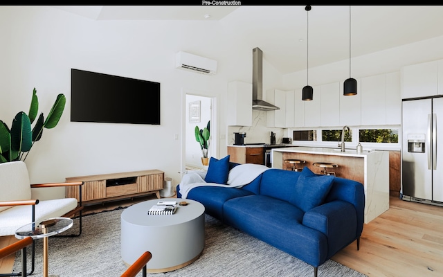 living room with an AC wall unit, sink, and light wood-type flooring