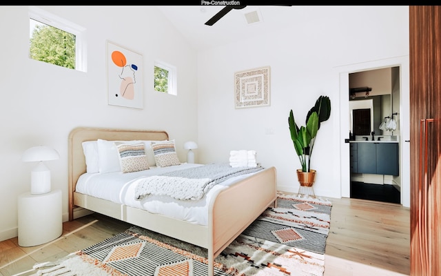 bedroom with connected bathroom, sink, ceiling fan, light hardwood / wood-style floors, and lofted ceiling