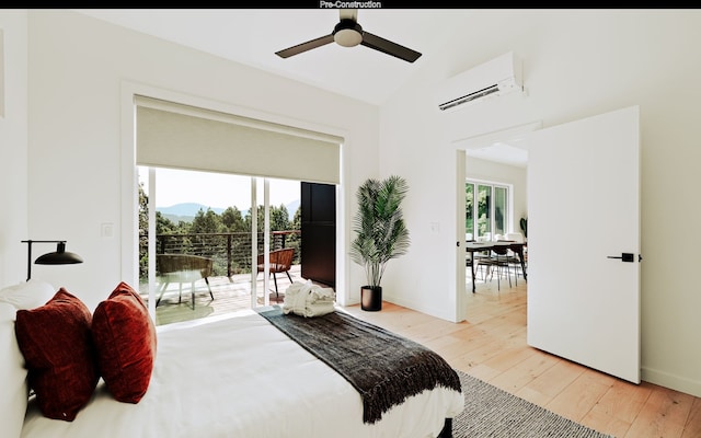 bedroom with access to exterior, vaulted ceiling, ceiling fan, light hardwood / wood-style flooring, and a wall unit AC