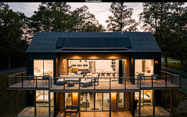 back house at dusk with an outdoor living space