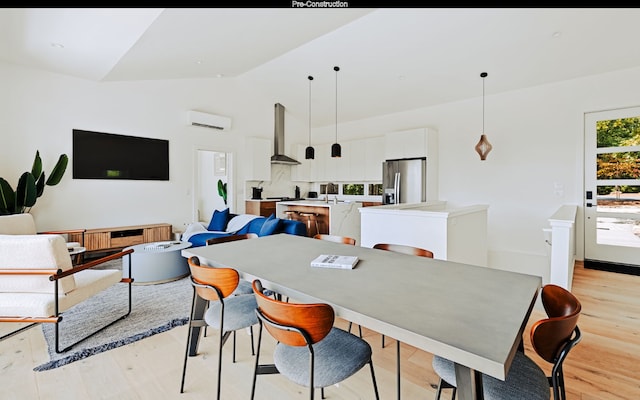 dining area with a wall mounted air conditioner, vaulted ceiling, light wood-type flooring, and sink