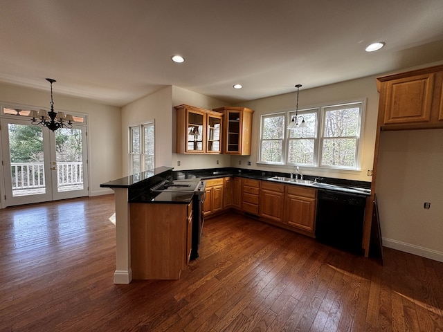 kitchen with a peninsula, black dishwasher, french doors, brown cabinets, and glass insert cabinets