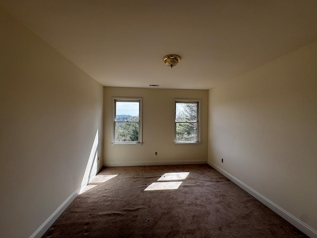 carpeted empty room featuring visible vents and baseboards