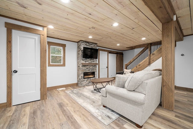 living room featuring hardwood / wood-style flooring, wood ceiling, and a fireplace