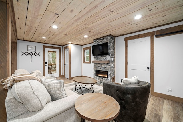 living room with crown molding, a fireplace, light hardwood / wood-style floors, and wooden ceiling