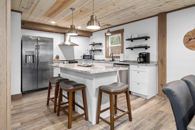 kitchen with white cabinets, hanging light fixtures, stainless steel appliances, wooden ceiling, and wall chimney exhaust hood