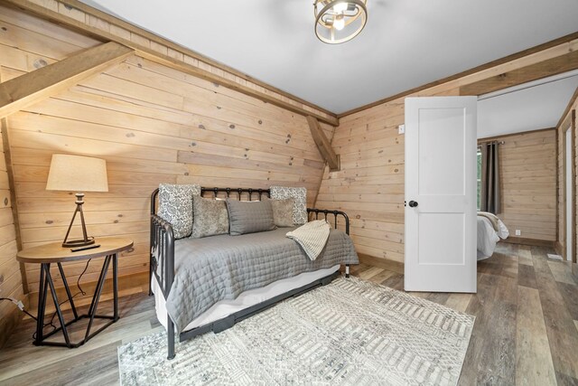 bedroom featuring hardwood / wood-style flooring and wooden walls
