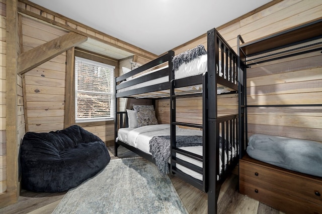 bedroom with hardwood / wood-style flooring and wood walls