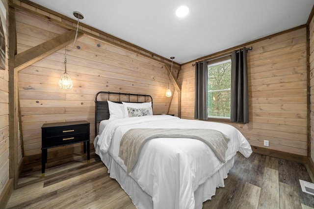 bedroom featuring hardwood / wood-style flooring and wooden walls