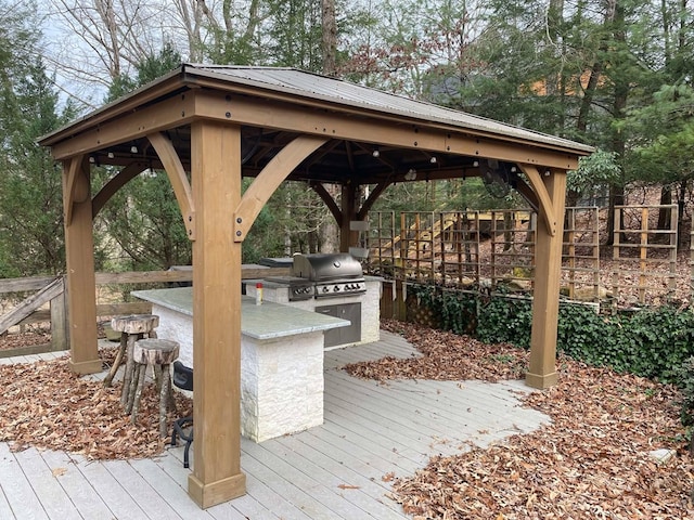 deck featuring a gazebo, an outdoor kitchen, area for grilling, and an outdoor bar