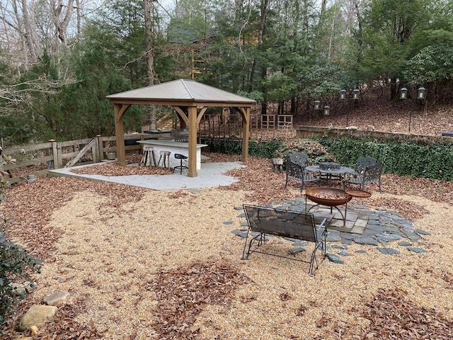 view of yard featuring a fire pit, a gazebo, and an outdoor bar