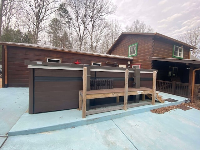 exterior space with a hot tub and a deck