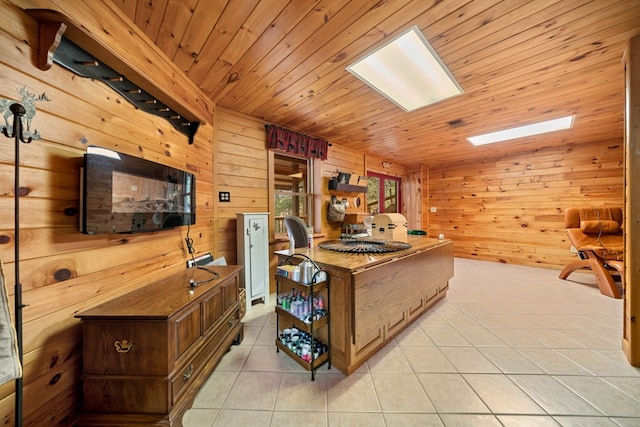 kitchen featuring light tile patterned floors, wood walls, wood ceiling, and a skylight