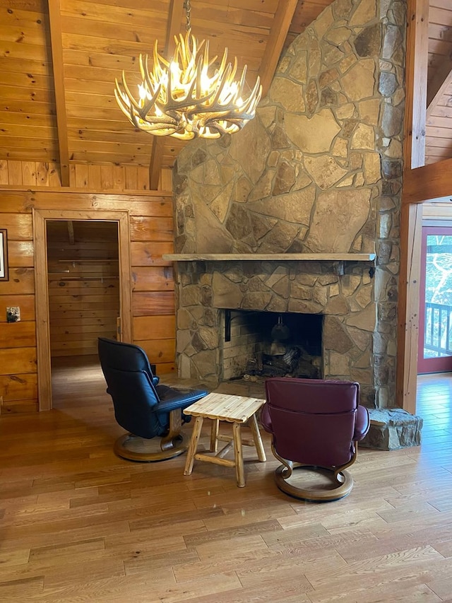 sitting room with wood walls, wood ceiling, wood-type flooring, beamed ceiling, and a fireplace