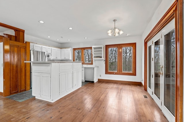 198 Hollow Log Trl, Ellijay, GA 30536 - kitchen with stainless steel appliances, a chandelier, hardwood / wood-style floors, white cabinetry, and baseboards