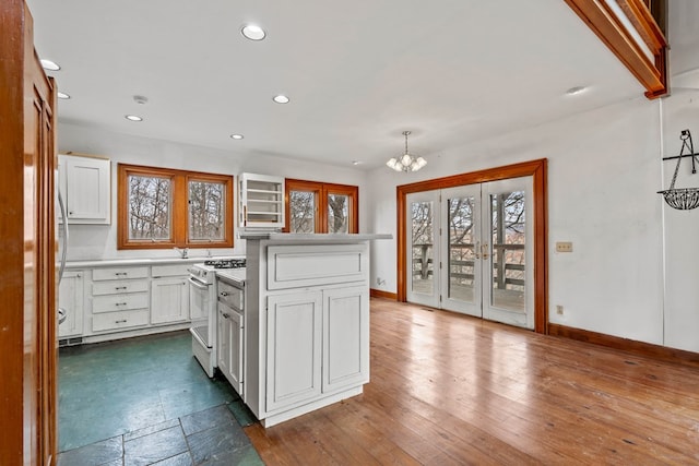 198 Hollow Log Trl, Ellijay, GA 30536 - kitchen with white gas range, a chandelier, baseboards, white cabinets, and recessed lighting