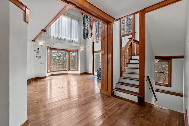 198 Hollow Log Trl, Ellijay, GA 30536 - unfurnished living room featuring hardwood / wood-style flooring, stairs, baseboards, and a high ceiling