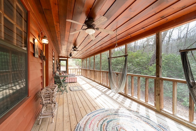 sunroom featuring wooden ceiling, ceiling fan, and a wealth of natural light