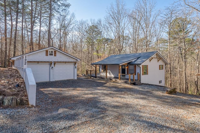 view of front of property with a garage, an outdoor structure, and covered porch