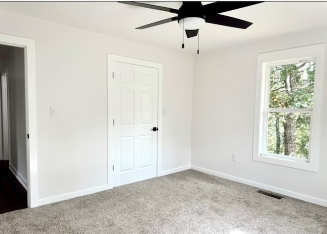 unfurnished bedroom with carpet floors, baseboards, multiple windows, and visible vents