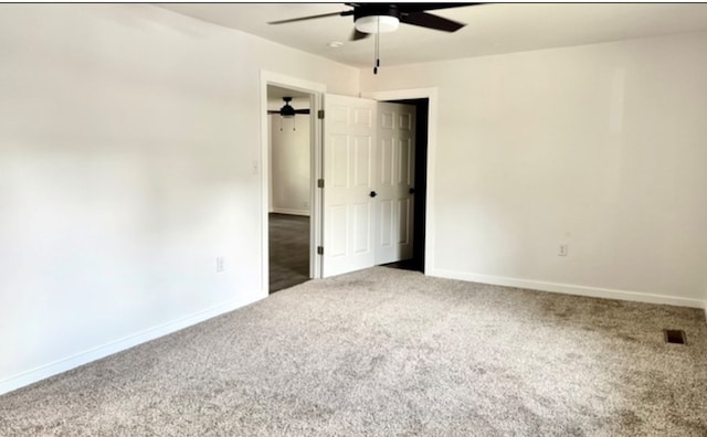 spare room featuring ceiling fan, carpet flooring, and baseboards