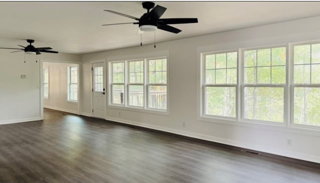 interior space with a ceiling fan, dark wood-style flooring, visible vents, and baseboards