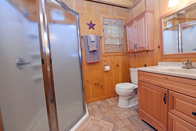 bathroom with wood walls, stone finish flooring, a stall shower, toilet, and vanity