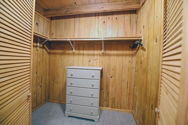 walk in closet featuring beam ceiling and carpet floors