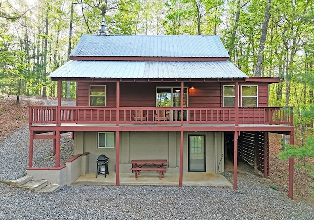 back of house with a deck, metal roof, and a patio area